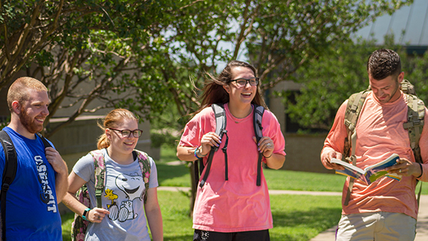 four students walking on campus