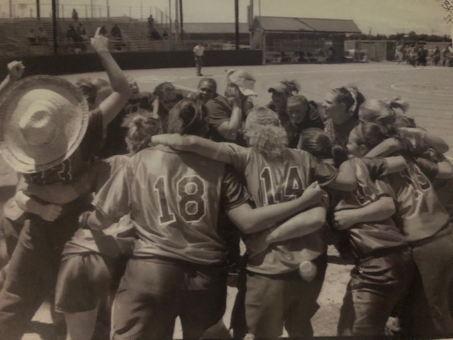 Former Lady Rebel Haylee Williams, former head softball coach Leigh Ebner (middle) and the 2004-06 Hill College softball team celebrate a win during the 2006 regional tournament. Ebner’s notorious restaurant birthday sombrero is worn by a player (left).