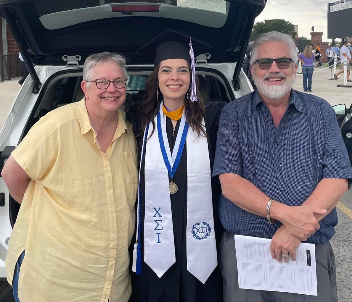 Michaela McCord (middle) with her mother, Arianne, and her father, Hill College professor Larry McCord, after her master's graduation.